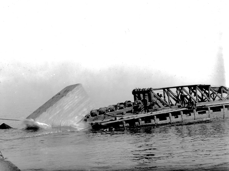 1915. Una barcaza lanzando bloques de hormigón