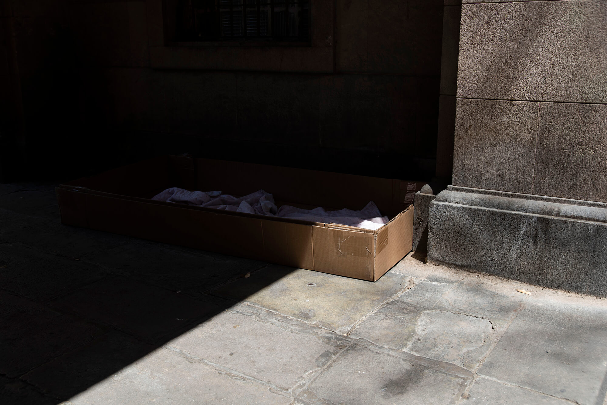 Cartones y mantas a modo de cama en la Plaça Vicenç Martorell