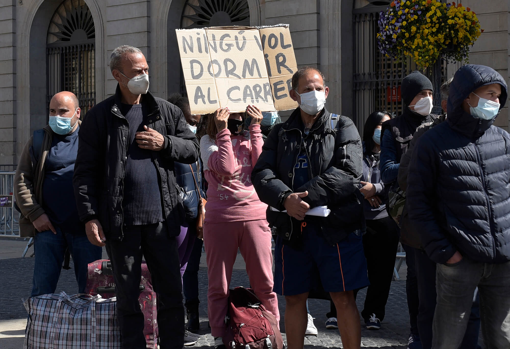 Una dona aguanta un cartell el dia que es presenta el Sindicat de Persones Sense Llar
