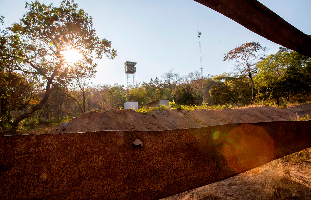Most of the Fazenda's security personnel's huts have been destroyed, but some remain in place. This one has a watchtower, and the bullet holes in the fence show that guards have been willing to shoot to keep locals out.
